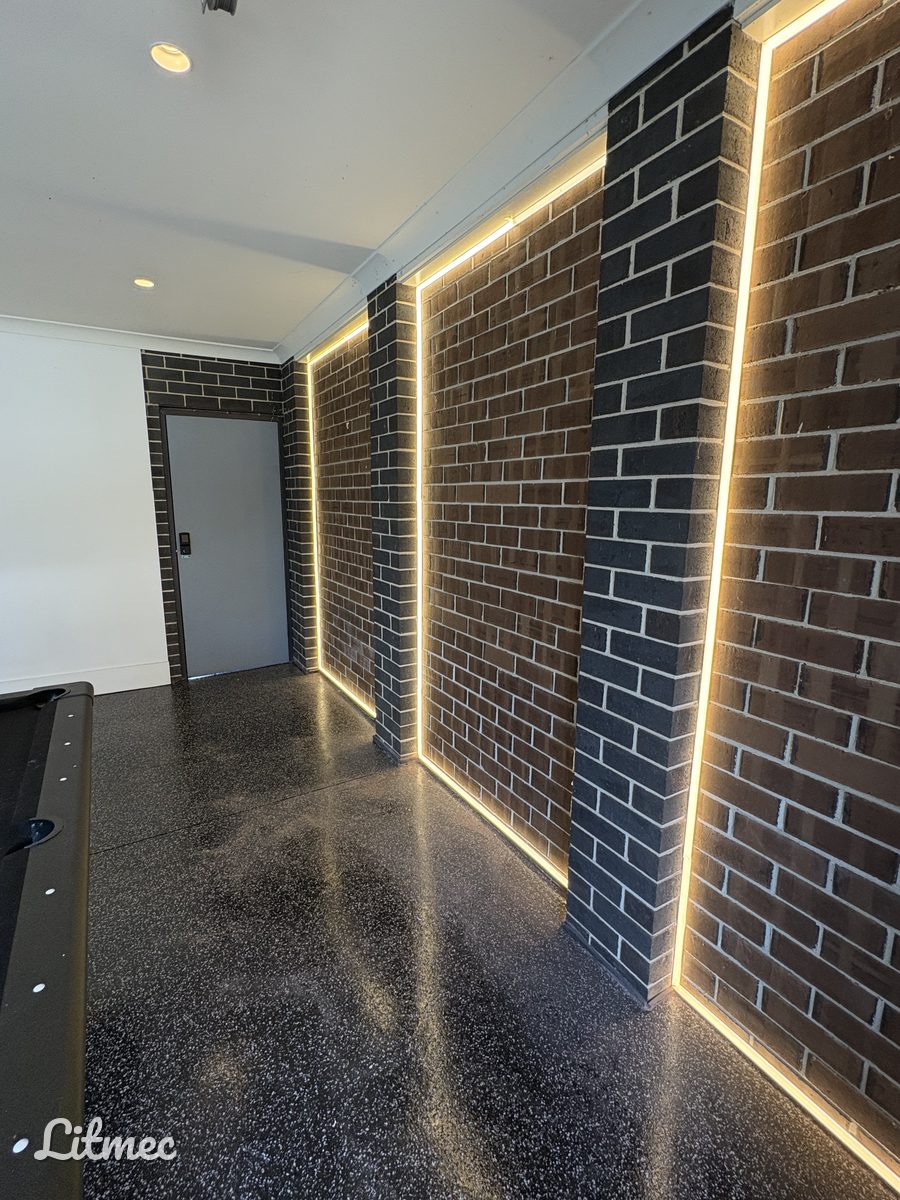 Warm concealed LED strip lighting framing brickwork in a converted garage