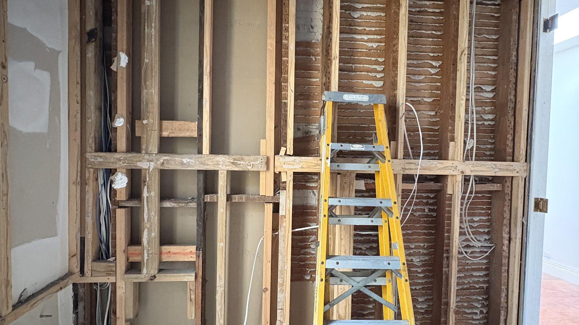 Renovation rough-in by Litmec Electrical — wall opened up and new cabling run through the framing