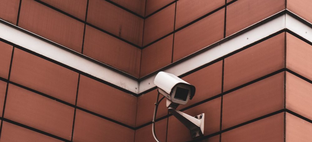 Externally mounted CCTV bullet camera and its cabling on a building corner